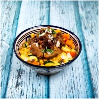 Een luchtige, gestoomde couscous, subtiel gekruid, met mals rundvlees, gekarameliseerde ui met rozijnen en geurige bouillon. Verrijkt met seizoensgebonden groenten zoals courgette, pompoen, wortel, wittekool en zoete aardappel, zodat je altijd geniet van de beste ingrediënten<br><br>